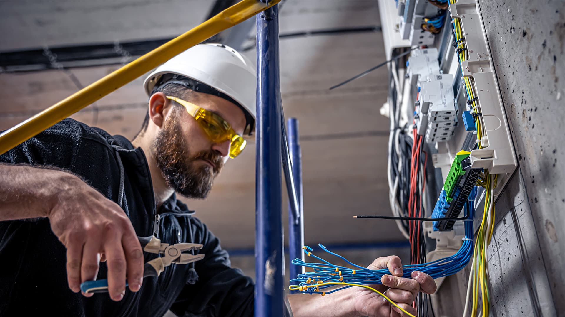 A commercial electrician working with various wires at a job site