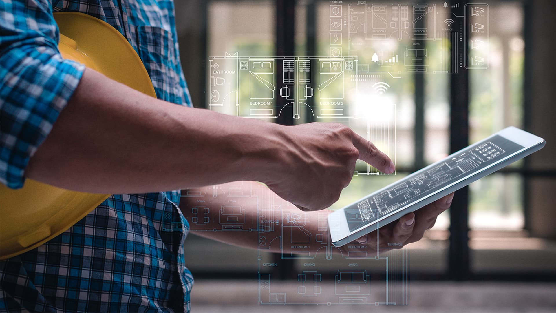 A commercial contractor looks at job site coordination software on a tablet