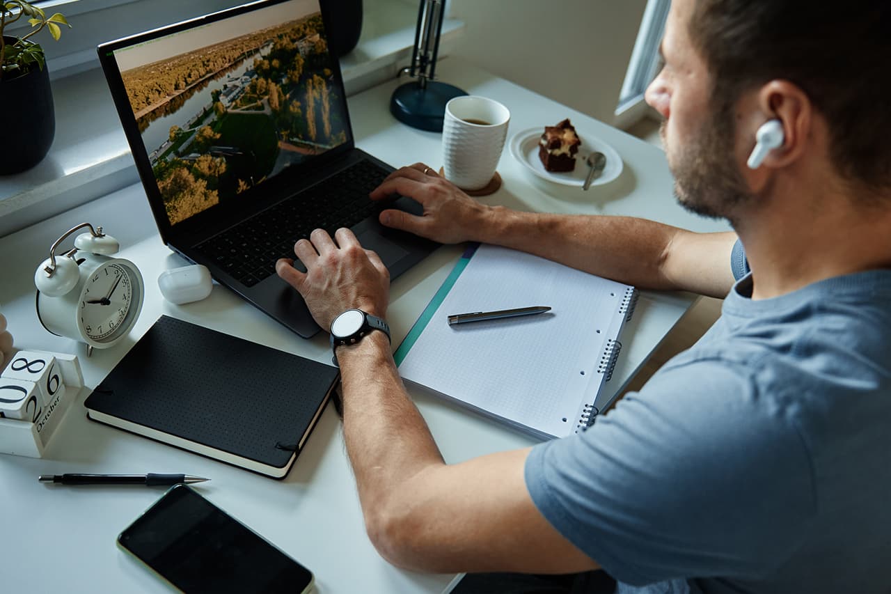 A solar contractor works indoors on a laptop