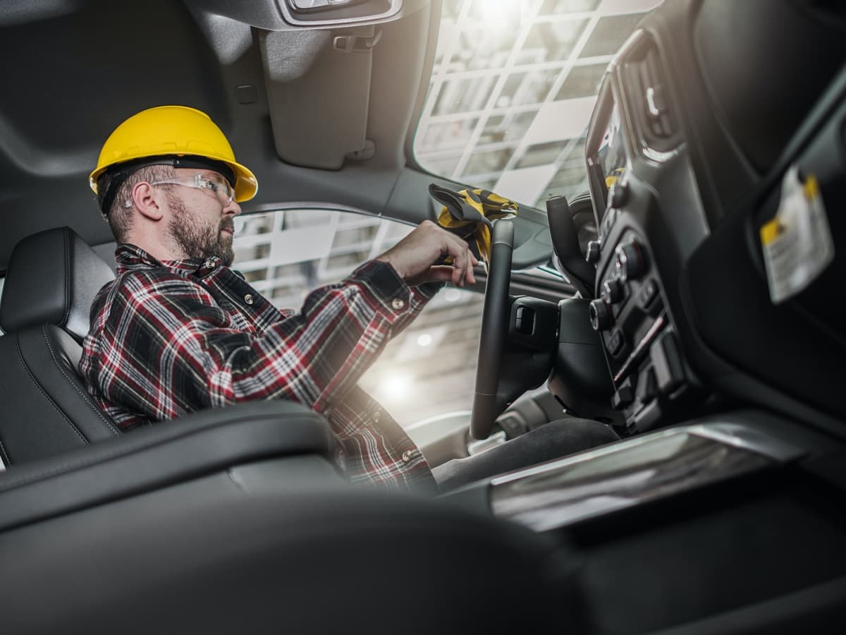 Driver in hard hat behind the wheel.